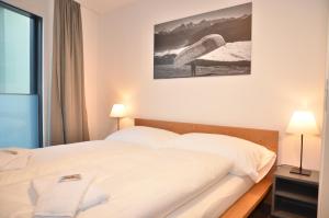 una camera con letto e una foto di una tavola da surf di Apartment Flüehblüemli - GriwaRent AG a Interlaken