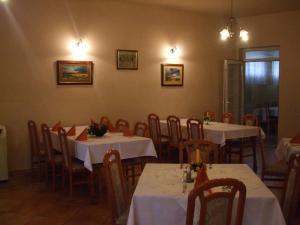 jadalnia ze stołami i krzesłami z białym blatem w obiekcie Gilde étterem és panzió w mieście Pilisvörösvár