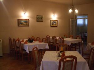 a dining room with tables and chairs with white table cloth at Gilde étterem és panzió in Pilisvörösvár