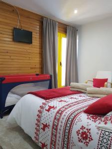 um quarto com uma cama e uma televisão na parede em Casa da Bela Vista - Serra da Estrela na Covilhã