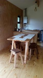 a large wooden table in a kitchen with benches at Cabañas Kuyen in Coihaique