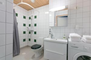 a white bathroom with a toilet and a sink at Sampo Studios in Rovaniemi +46 photos
