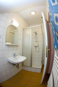 uma casa de banho com um chuveiro e um lavatório. em Gilde étterem és panzió em Pilisvörösvár