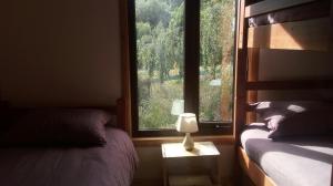 a bedroom with two beds and a window at Cabañas Kuyen in Coihaique