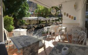 a patio with white tables and chairs and umbrellas at Hotel Villa Delle Palme in Positano in Positano