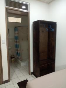 ein Badezimmer mit einer Dusche und einem Holzschrank in der Unterkunft Hotel Don Fito in Golfito