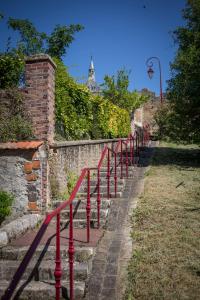une rangée de rails rouges sur un mur en pierre dans l'établissement Le Sauvage, à Château-Renard
