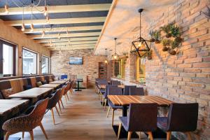 a dining room with tables and chairs and a brick wall at Pansion Winter in Jahorina