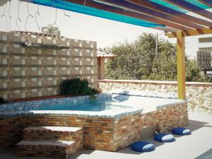 a swimming pool in a backyard with a brick wall at Hotel Rodadero Dorado in Santa Marta