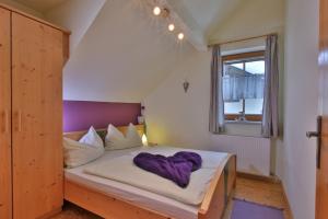 Gästehaus Berger في تروبولاخ: غرفة نوم مع سرير مع بطانية أرجوانية عليه
