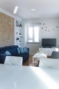 un salon avec un canapé bleu et une télévision dans l'établissement Quiet and Bright Apartment 16 by Lisbonne Collection, à Lisbonne