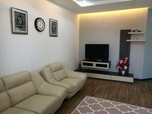 a living room with a couch and a tv at Barakah Homestay in Alor Setar