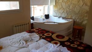 a bathroom with a tub and a bed and a sink at Complejo Pampa in Mar de las Pampas +42 photos