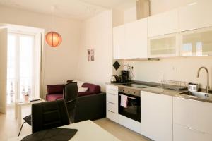 eine Küche mit weißen Schränken und ein Wohnzimmer in der Unterkunft Classic and Comfortable Topfloor Apartment 13 by Lisbonne Collection in Lissabon