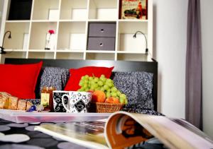 ミラノにあるBnButler - Col di Lana - Navigli Apartment - Darsenaのソファに果物のトレイを載せたテーブル