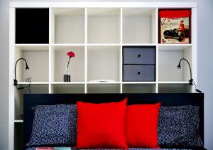 ミラノにあるBnButler - Col di Lana - Navigli Apartment - Darsenaのベッドルーム1室(赤い枕のベッド1台付)