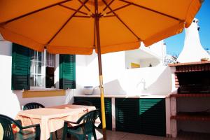 einem orangenen Regenschirm auf einem Tisch in der Unterkunft Milfontes Villa in Vila Nova de Milfontes