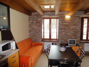 SCI AI PIEDI,PASSEGGIATE,MOUNTAIN BIKE,RELAX في باسو ديل تونالي: غرفة معيشة مع أريكة برتقالية وطاولة