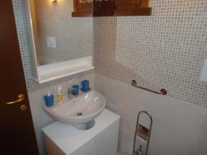 SCI AI PIEDI,PASSEGGIATE,MOUNTAIN BIKE,RELAX في باسو ديل تونالي: حمام مع حوض أبيض ومرآة