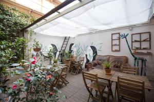 a patio with tables and chairs and plants at Tomato Backpackers in Turin