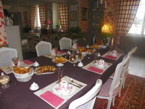 une table remplie de denrées alimentaires et de assiettes alimentaires dans l'établissement Chambres d'hôtes du Perray, à Candé