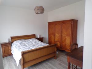 a bedroom with a bed and a wooden cabinet at Roseau in Berck-sur-Mer