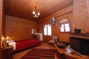 1 dormitorio con 1 cama y TV en una habitación en Guesthouse Alonistaina en Alonistaina