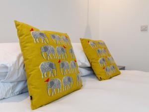 Dale House - Vivre Retreats في بورنموث: وسادتين صفراء جالستين فوق السرير