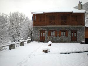 una casa con la neve per terra davanti di Guesthouse Alonistaina ad Alonístaina