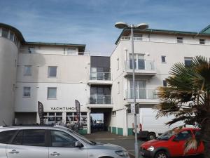 a white building with a red car parked in front of it at Ynys Lawd, Holyhead Marina in Holyhead +10 photos