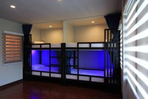 a room with two bunk beds with blue lighting at T2 Hostel Thappraya 12 in Pattaya South +1 photo