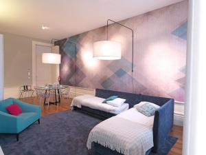 Habitación con 2 camas, silla y mesa. en FLH New Oporto Apartments - Mouzinho, en Oporto