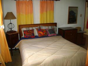 a bedroom with a large white bed with pillows at Jardin Secreto Russell Maipu in Mendoza