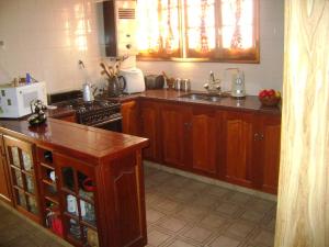 a kitchen with wooden cabinets and a stove top oven at Jardin Secreto Russell Maipu in Mendoza +20 photos