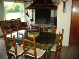 comedor con mesa, sillas y chimenea en Jardin Secreto Russell Maipu en Mendoza