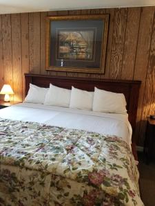 a bedroom with a large bed with a floral comforter at Gold Pan Lodge in Quincy