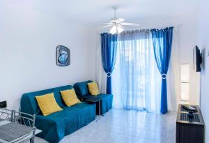 a living room with a blue couch with yellow pillows at Pafia 3 Holiday Apartment in Paphos City