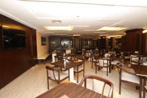 comedor con mesas y sillas de madera en Al Zaitouna Hotel, en Áqaba