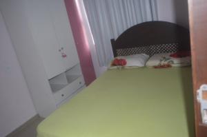 1 dormitorio con mesa verde, silla y espejo en Sobrado, en Itapema