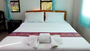 Golden Palm Resort في شيانغ ماي: سرير ابيض كبير وربطه مقوس