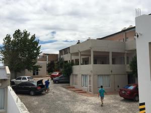 deux hommes marchant sur un parking devant un bâtiment dans l'établissement Complejo Brisas Místicas, à Las Grutas 12 autres photos