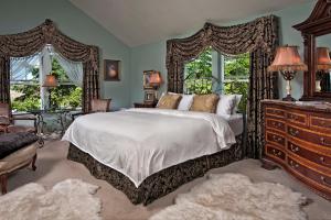 a bedroom with a bed and a dresser and windows at Cozy Rose Inn in Prosser