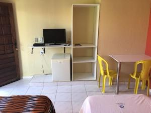 a room with a desk with a computer and yellow chairs at Pousada Fragata in Porto De Galinhas