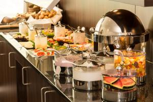 a kitchen with a buffet of food on a counter at Heikotel - Hotel Windsor in Hamburg