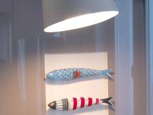ポルトにあるFLH New Oporto Apartments - Cardosasの壁に付けられた灯りの下に飾られたおもちゃの魚2匹