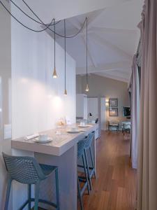 a kitchen with a bar with chairs and a living room at FLH New Oporto Apartments - Cardosas in Porto
