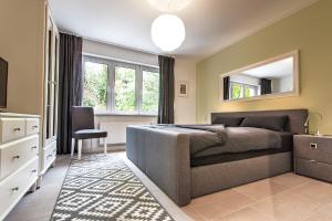 a bedroom with a bed and a mirror and a chair at Charming CHARLOTTE in Saarbrücken