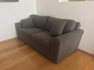 a gray couch with two pillows sitting in a room at Beautiful, down-town in Mexico City