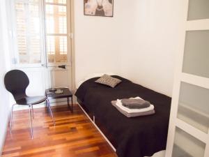 a small bedroom with a bed and a chair at Torres Rojo in Barcelona