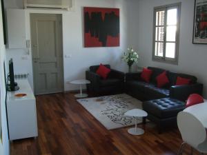 バルセロナにあるTorres Rojoのリビングルーム(黒いソファ、赤い枕付)